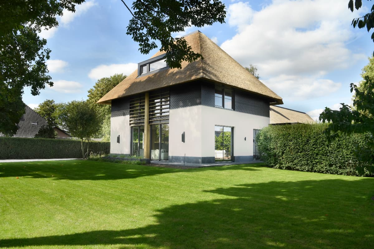 Lichte moderne woonkamer met grote ramen en houten vloer
